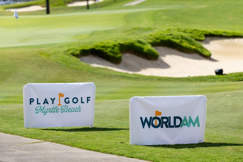 World Am and Play Golf Myrtle Beach tee banners beside a bunkered green at a host course