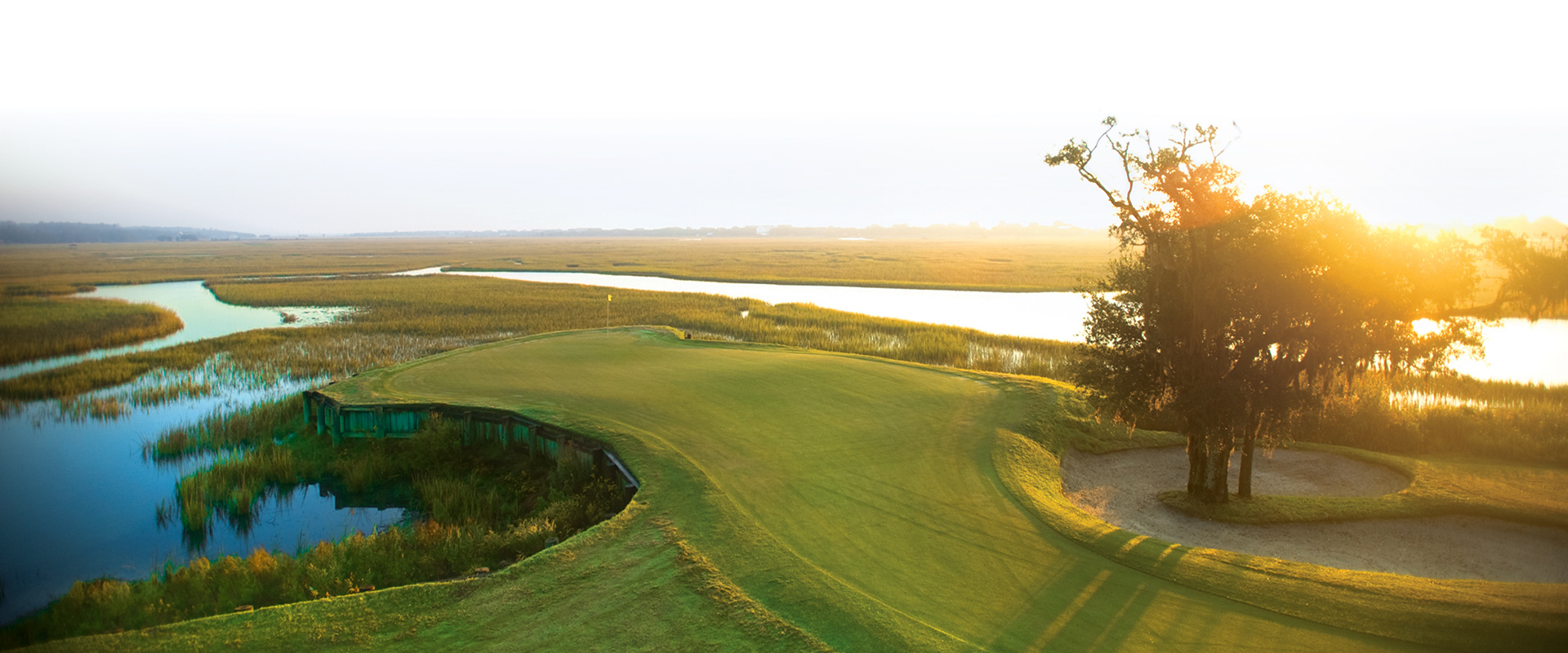 Wide view across the salt marsh at Pawleys Plantation at sunrise with the 13th green in the foreground