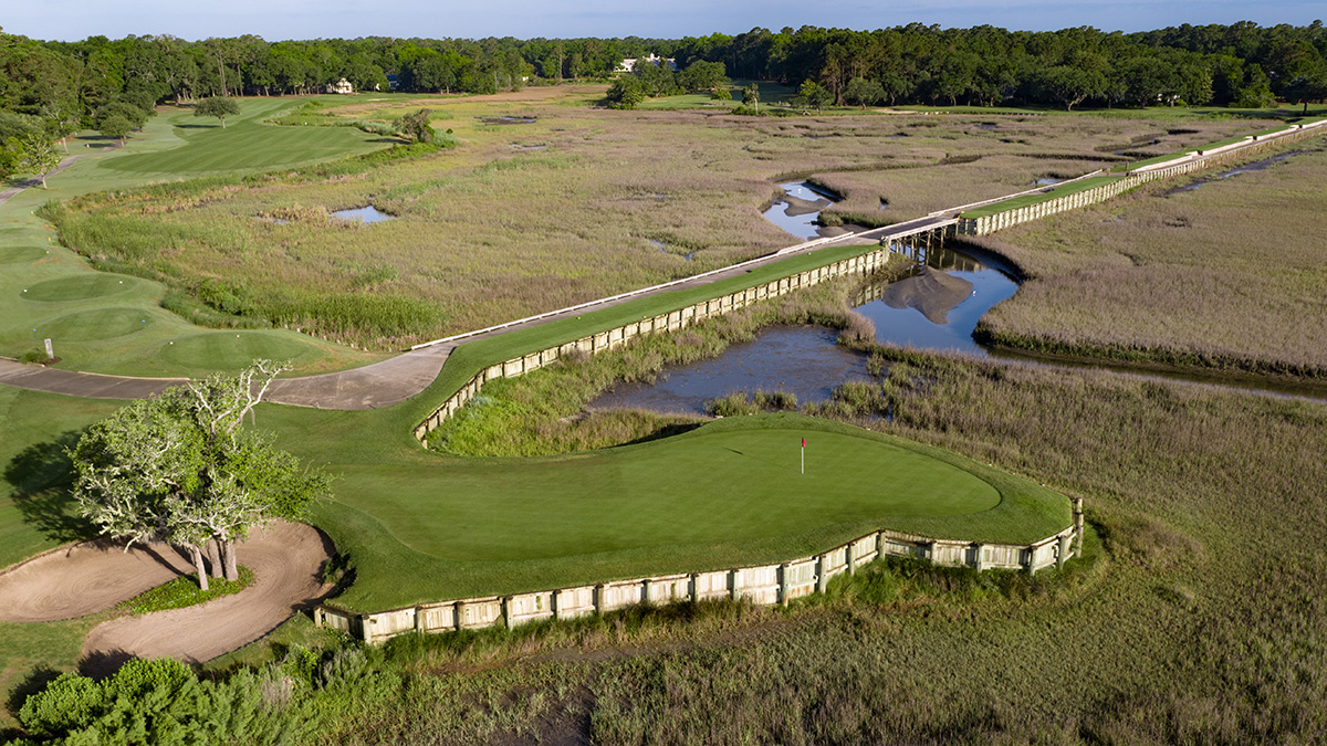 Aerial view of the bulkheaded 13th green at Pawleys Plantation surrounded on three sides by salt marsh, with the long dike to the tees running off behind it